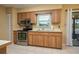 Well-lit kitchen features stainless steel appliances, wooden cabinets, and a view to the backyard at 3245 Prairie Dunes E Cir, Lakeland, FL 33810