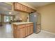 Kitchen island and stainless steel fridge in open floor plan leading to bright and airy living area at 3245 Prairie Dunes E Cir, Lakeland, FL 33810