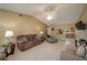 Inviting living room with tile flooring, vaulted ceiling, and a view of the kitchen, all bathed in natural light at 3245 Prairie Dunes E Cir, Lakeland, FL 33810
