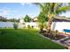 Manicured backyard with lush green grass, a white fence, mature trees, and landscaping at 3828 Eloise Estates Ct, Winter Haven, FL 33881