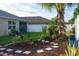 Landscaped backyard featuring a large palm tree and a paver walkway leading through the garden at 3828 Eloise Estates Ct, Winter Haven, FL 33881