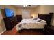 Well-lit bedroom with a dark wood frame bed, TV, dressers, wood flooring and window at 3828 Eloise Estates Ct, Winter Haven, FL 33881