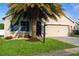 Charming home with a palm tree, manicured lawn, and a two-car garage at 3828 Eloise Estates Ct, Winter Haven, FL 33881