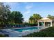 Beautiful community pool area with lounge chairs, lush landscaping, and a covered pavilion at 3828 Eloise Estates Ct, Winter Haven, FL 33881