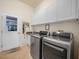 A convenient laundry room with modern washer, dryer, and ample white cabinet storage at 4004 Sable Loop Dr, Lake Wales, FL 33859