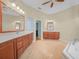 Main bathroom featuring tile flooring, wood cabinetry, double sinks, and a view of the tub at 4004 Sable Loop Dr, Lake Wales, FL 33859