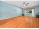 Spacious main bedroom with hardwood floors, ceiling fan, and a bright window with curtains at 4004 Sable Loop Dr, Lake Wales, FL 33859