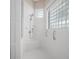 All-white shower features safety bars and glass block window for natural light at 4004 Sable Loop Dr, Lake Wales, FL 33859