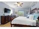 Sunlit bedroom featuring wood flooring, large bed, dresser and mounted TV at 4175 Muirfield Loop, Lake Wales, FL 33859