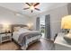 Comfortable bedroom with a ceiling fan, laminate wood flooring, and soft lighting at 4175 Muirfield Loop, Lake Wales, FL 33859