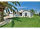 Single-story home showcasing a well-kept lawn, brick driveway, and lush tropical landscaping at 4175 Muirfield Loop, Lake Wales, FL 33859