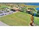 Aerial view of a golf course with a 2-story clubhouse, golf carts, and picturesque landscaping at 4175 Muirfield Loop, Lake Wales, FL 33859