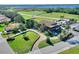 Aerial view of a 2-story clubhouse, surrounded by lush greenery, a golf course, and a large lake at 4175 Muirfield Loop, Lake Wales, FL 33859