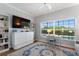 Bright living space, including a view of the pool, a large TV, a desk and white shelves at 4175 Muirfield Loop, Lake Wales, FL 33859