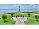 Scenic lakeside memorial site showcasing American flags and commemorative plaques amidst lush greenery and serene waters at 4175 Muirfield Loop, Lake Wales, FL 33859