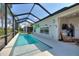 Long in-ground pool under a screened enclosure, with a lounge area, providing a resort-like experience at 4175 Muirfield Loop, Lake Wales, FL 33859