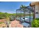 Screened-in pool with brick paver patio, tropical plants, grill, and outdoor seating at 4175 Muirfield Loop, Lake Wales, FL 33859