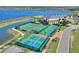 Aerial view of tennis and pickleball courts near clubhouse, next to a beautiful lake creating a picturesque setting at 4175 Muirfield Loop, Lake Wales, FL 33859