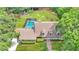Expansive property featuring a sparkling screened pool, lush landscaping, and a serene pond, all viewed from above at 418 North Rd, Lakeland, FL 33809