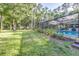 Sprawling backyard with lush green grass and landscaping adjacent to a refreshing pool area at 418 North Rd, Lakeland, FL 33809