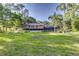 Expansive backyard with mature trees, and a screened-in pool area attached to a brick two-story home at 418 North Rd, Lakeland, FL 33809
