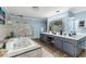 A bright bathroom with marble countertops, double sink vanity, and a tiled jacuzzi tub at 418 North Rd, Lakeland, FL 33809
