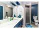 Stylish bathroom with a marble countertop, navy blue cabinets, framed mirror, and walk-in shower at 418 North Rd, Lakeland, FL 33809