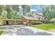 Side view of a brick home with a covered carport and a well-maintained lawn, framed by mature trees at 418 North Rd, Lakeland, FL 33809