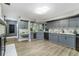Spacious kitchen with modern gray cabinets, marble countertops, wine cooler, and wood flooring at 418 North Rd, Lakeland, FL 33809