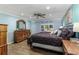 Main bedroom with a king-size bed, ceiling fan, and blue walls at 418 North Rd, Lakeland, FL 33809