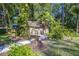 A brick outbuilding with walkway surrounded by lush greenery, enhancing the backyard appeal at 418 North Rd, Lakeland, FL 33809