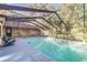 Screened-in pool featuring a blue tile border, a brick wall, and ample lounging space to relax and enjoy at 418 North Rd, Lakeland, FL 33809