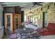 Relaxing screened-in porch featuring a brick wall, dining set, and lounge chair with ceiling fans at 418 North Rd, Lakeland, FL 33809
