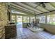 A covered and screened-in porch with an outdoor kitchen area and table, offering pool views at 418 North Rd, Lakeland, FL 33809