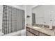 Clean bathroom featuring a granite vanity and shower with black and white patterned curtain at 428 Aragosa Dr, Davenport, FL 33837
