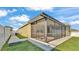 Exterior of the home with a screened-in lanai, white fence, and lush green lawn at 428 Aragosa Dr, Davenport, FL 33837