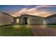 Inviting single-story home with a well-manicured lawn and a brick-paved driveway at 428 Aragosa Dr, Davenport, FL 33837