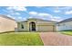 Charming one-story home featuring a well-maintained lawn and a brick-paved driveway at 428 Aragosa Dr, Davenport, FL 33837