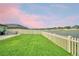 The back yard overlooks a scenic water view and includes a firepit and a white picket fence at 4400 Trotters Way, Lakeland, FL 33801
