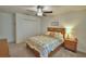 Cozy bedroom features a ceiling fan, large bed, and a convenient nightstand at 4400 Trotters Way, Lakeland, FL 33801