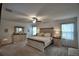 Bright main bedroom featuring carpet, ceiling fan, ensuite bathroom, and a large dresser at 4400 Trotters Way, Lakeland, FL 33801