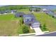 Lovely aerial view showcasing the property with its expansive lawn, neighboring houses, and scenic lake view at 445 Waterfern Trail Dr, Auburndale, FL 33823