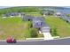 Aerial view of 2-story home featuring a 2-car garage, lush green lawn and mature trees at 445 Waterfern Trail Dr, Auburndale, FL 33823
