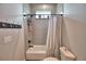This bathroom features a white tub with gray tiling and a decorative striped shower curtain at 445 Waterfern Trail Dr, Auburndale, FL 33823