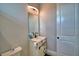 A sleek bathroom vanity with a modern faucet and a large mirror illuminated by a curved light fixture at 445 Waterfern Trail Dr, Auburndale, FL 33823