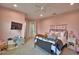 Bedroom featuring pink walls, carpet flooring, a ceiling fan, and comfortable furnishings at 445 Waterfern Trail Dr, Auburndale, FL 33823