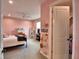 Bedroom featuring pink walls, carpet flooring, ceiling fan, and access to walk-in closet at 445 Waterfern Trail Dr, Auburndale, FL 33823