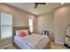 Comfortable bedroom with a full-size bed, two windows with blinds, and a ceiling fan for added comfort at 445 Waterfern Trail Dr, Auburndale, FL 33823