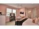 Bedroom featuring pink walls, carpet flooring, a ceiling fan, and comfortable furnishings at 445 Waterfern Trail Dr, Auburndale, FL 33823