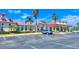 Beautiful clubhouse featuring a red roof, palm trees, ample parking and well-maintained landscaping at 445 Waterfern Trail Dr, Auburndale, FL 33823